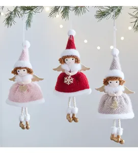 Dettaglio di tre bambole angelo di Natale in maglia fatte a mano appese a un albero