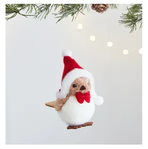 Gros plan d'un oiseau en peluche avec bonnet de Noël rouge et nœud papillon