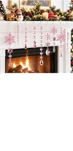 Macro view of pink acrylic snowflake and icicle ornaments hanging on a white mantel.