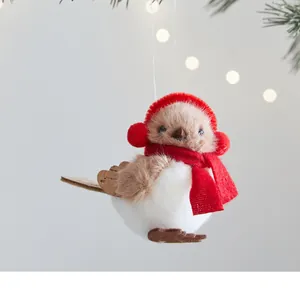 Gros plan d'un oiseau en peluche avec écharpe rouge et cache-oreilles pour Noël
