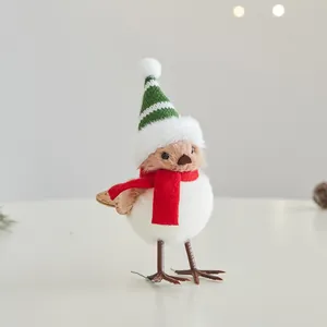 Simpatica statuina di uccello di Natale con cappello a strisce verdi e sciarpa rossa.