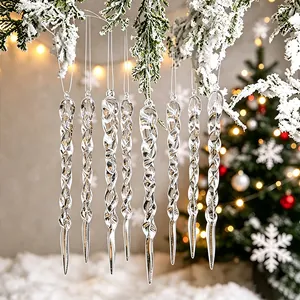 Set of elegant clear twisted icicle ornaments hanging on snowy Christmas tree branches