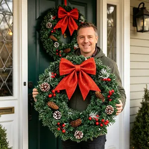 Couronne de Noël festive avec un grand nœud rouge scintillant, des pommes de pin et baies