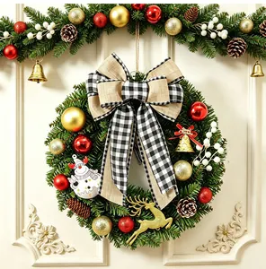 Festlicher Weihnachtskranz mit karierter Schleife und Ornamenten an weißer Tür als Dekoration
