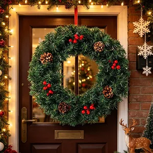 Lush Christmas wreath with red berries and pine cones on a rustic dark wooden door.