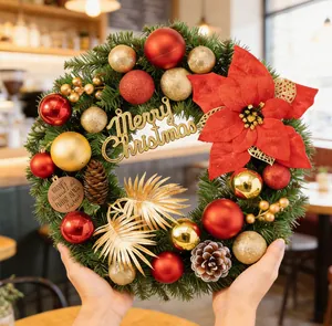 Detailansicht eines Weihnachtskranzes mit rotem Weihnachtsstern, Goldkugeln und Zapfen.