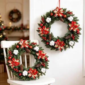 Eleganter Weihnachtskranz mit roten Poinsettien, Tannenzapfen und Baumwolle für die Deko
