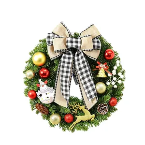Traditioneller Weihnachtskranz mit schwarz-weißer Karoschleife für die Türdekoration