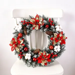 Ghirlanda di Natale artificiale con stelle di Natale rosse e pigne su sedia bianca