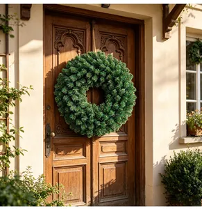 Corona de Navidad de pino verde realista colgada en una puerta de madera clásica