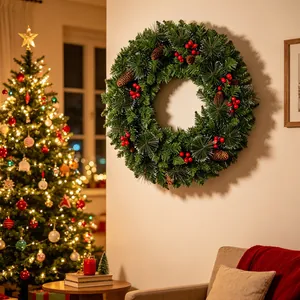 Festive PVC Christmas wreath with pine cones and red berries on a warm living room wall