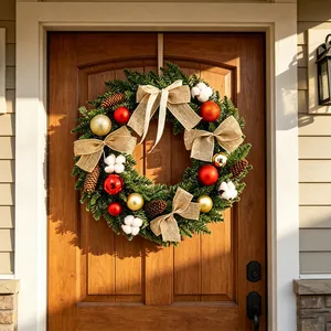 Élégante couronne de Noël avec des boules rouges et nœuds en toile sur une porte