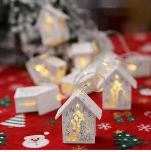Close-up of white wooden house Christmas string lights with warm LED glow.