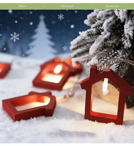 Beautiful close-up of red wooden house-shaped Christmas LED string lights in a snow scene.