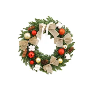 Couronne de Noël traditionnelle avec boules rouges, pommes de pin et nœuds en toile de jute