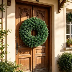 Exuberante corona de pino artificial verde en puerta de madera para decoración navideña.
