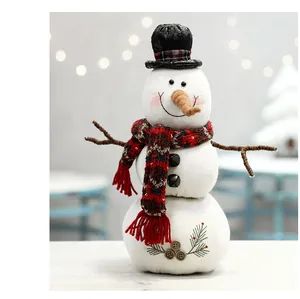 Detailweergave van een charmant pluche sneeuwpop-beeldje met een rode geruite sjaal.