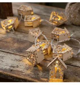 Wooden house Christmas string lights with warm LED glow and Santa carvings.