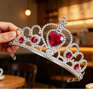 Detailed macro view of a sparkling princess tiara featuring a large red heart-shaped gemstone