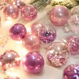 Primo piano di palline di Natale rosa glitterate con calde luci festive soffuse