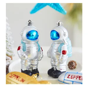 Detailed view of silver astronaut Christmas tree ornaments with shiny blue glitter accents.