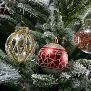 Prachtige beschilderde kerstballen hangend aan een met sneeuw bedekte kerstboomtak
