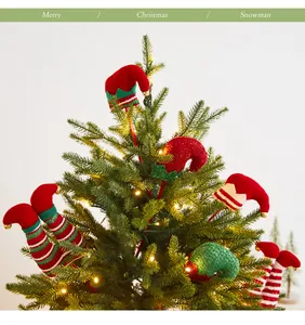 Detail von festlichen Elfenbeinen und Hüten als Schmuck in einem Weihnachtsbaum.