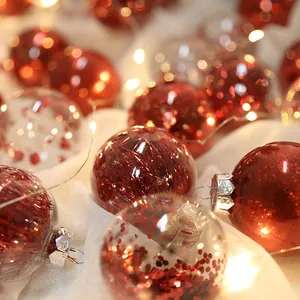 Eleganti palline di Natale trasparenti con paillettes rosse e decorazioni festive lucide