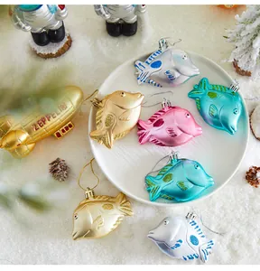 Detailed view of colorful fish-shaped Christmas tree ornaments on snowy background