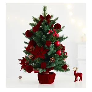 Detailed view of a mini Christmas tree with festive red velvet decorations