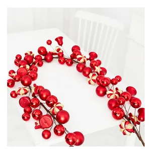 Gros plan d'une guirlande de Noël festive rouge et or avec cloches et étoiles