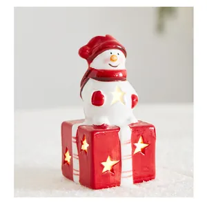Detaillierte Makroansicht eines leuchtenden Keramik Schneemanns auf einer Geschenkbox