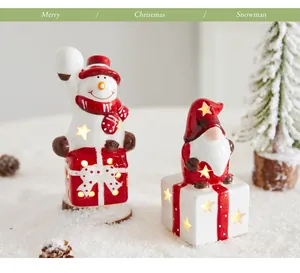 Detailansicht leuchtender Schneemann und Gnom Keramik Weihnachtsdeko im Schneebild.