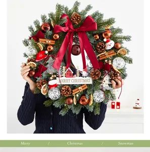 Vue détaillée d'une couronne de Noël festive avec un grand nœud rouge et des pommes de pin
