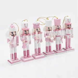 Gedetailleerde set van zes roze en witte houten notenkrakerfiguren met gouden koordjes.