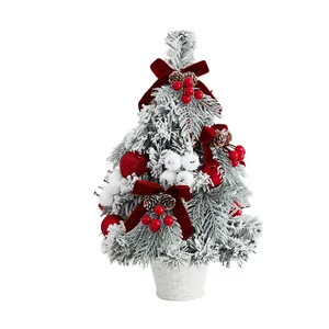 Mini flocked Christmas tree featuring red bows and berries for tabletop display