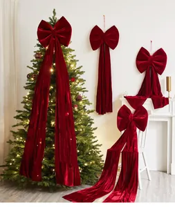 Grandi fiocchi eleganti in velluto rosso che decorano l'albero e scene natalizie