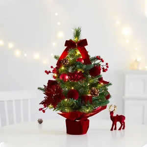 Elegant tabletop pre-lit mini Christmas tree decorated with red velvet bows and berries
