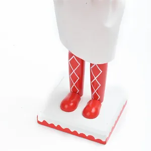 Detalle de las piernas pintadas de rojo y la base de un cascanueces chef de madera