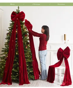 Vista dettagliata di un grande fiocco natalizio in velluto rosso su un albero di Natale