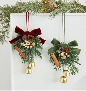 Detalle de adornos navideños colgantes con lazos de terciopelo y campanas doradas