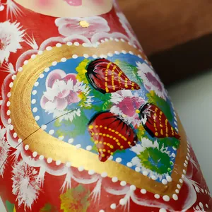 Makroaufnahme detaillierter handbemalter Blumenmuster auf einer Matroschka