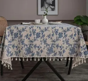 Detailed view of the premium linen tablecloth with blue floral prints and tassel fringe