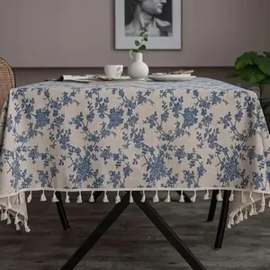Elegant linen tablecloth with blue floral pattern and tassel fringe for home decor.