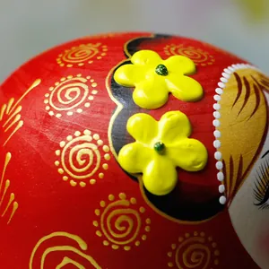 Makro-Detail des handbemalten Blumenmusters auf einer traditionellen russischen Matroschka
