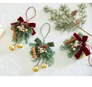 Primer plano de adornos navideños con lazos de terciopelo rojo y campanas doradas