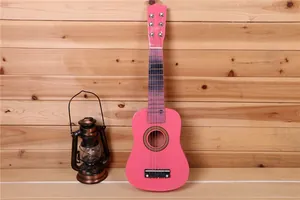Guitare enfant en bois rose de 21 pouces avec lanterne vintage contre un mur en bois rustique