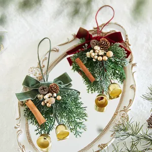 Elegantes adornos navideños con lazos de terciopelo, piñas y campanas en bandeja vintage