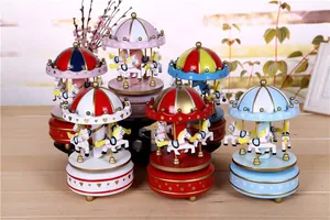 Close-up of five colorful carousel music boxes on a wooden table surface