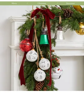 Detailed view of festive Christmas iron bells with Noel patterns and pine cone decor.